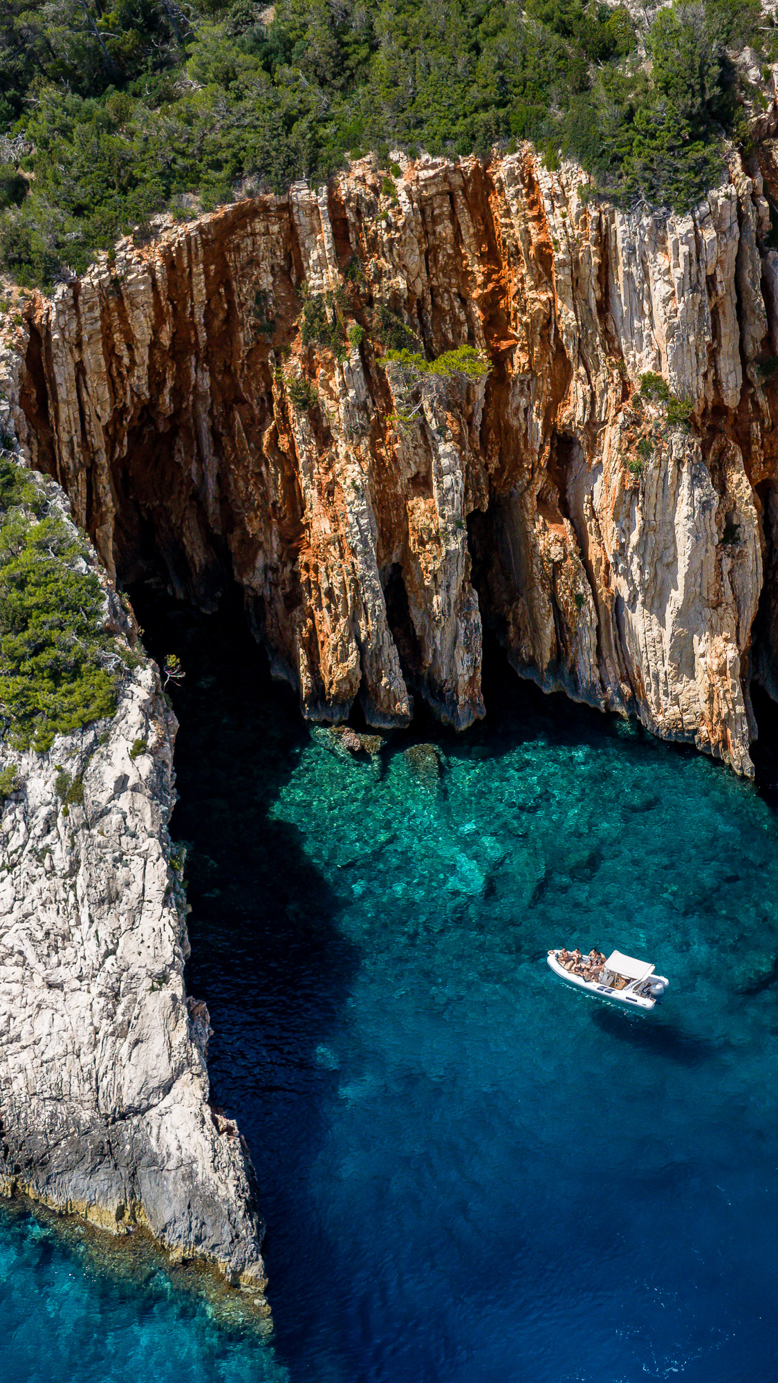 Red Rocks cliffs and speedboat aerial drone view - boat tour from Hvar Croatia